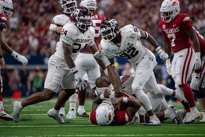 Texas A&M Aggies linebacker Chris Russell Jr. (24) and defensive lineman Malick Sylla (92) celebrate a sack of Arkansas Razorbacks quarterback KJ Jefferson (1) during the second half at AT&T Stadium.